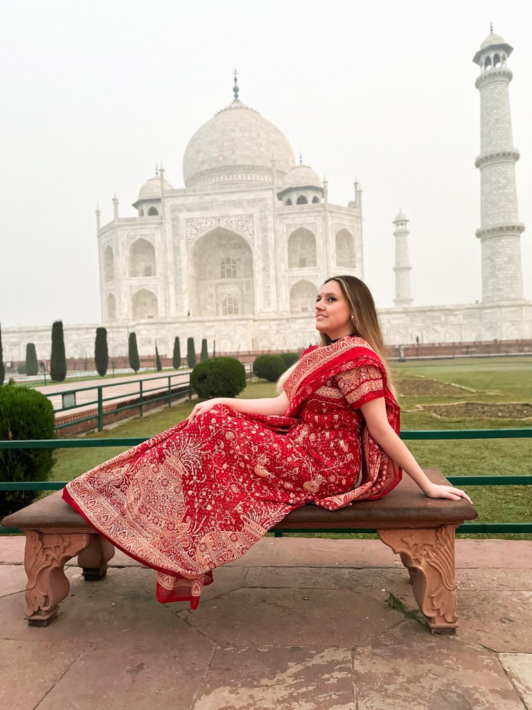 Retrato personal al amanecer frente al Taj Mahal, luciendo sari rojo tradicional y bindi